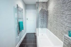 a bathroom with a tub and a glass shower at 4 Bedroom in Finchley Road in London