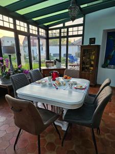 une salle à manger avec une table et des chaises blanches dans l'établissement La demeure de Liers, à Sainte-Geneviève-des-Bois