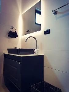 een badkamer met een zwarte wastafel en een spiegel bij Vineyard Apartment in Ohrid