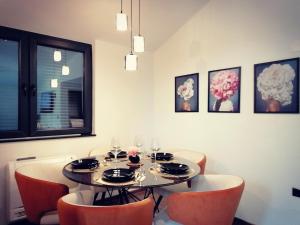 een eetkamer met een tafel met oranje stoelen bij Vineyard Apartment in Ohrid +8 foto's