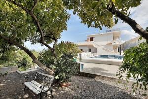 a bench sitting next to a house with a swimming pool at Punta del Sol Familiar in Tijarafe