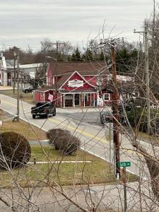 a car driving down a street in front of a red building at The Happy Place in Tilghman Island