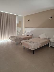 two beds sitting in a room with at Dúplex de 2 habitaciones y 2 baños y con jackuzzi privado in Tamaimo