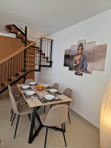 una sala da pranzo con tavolo, sedie e scala di Dúplex de 2 habitaciones y 2 baños y con jackuzzi privado a Tamaimo