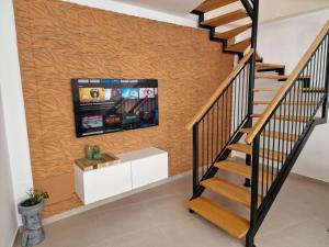 una scala con TV a schermo piatto a parete di Dúplex de 2 habitaciones y 2 baños y con jackuzzi privado a Tamaimo