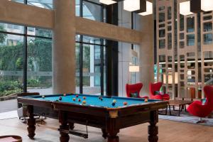 a billiard room with a pool table and red chairs at Aloft Jakarta Wahid Hasyim in Jakarta