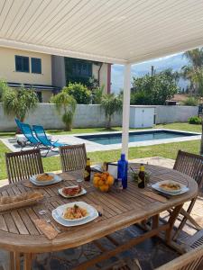 un tavolo in legno con piatti di cibo sopra di Villa Egiza con piscina e accesso diretto al mare a Carini