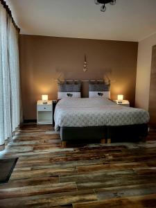 a bedroom with a bed and two lamps on the floor at Les chambres de la fontaine de brul in Sainte-Ode