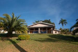 a house with a palm tree in front of it at Paraty Hotel Fazenda & Spa in Ibiúna