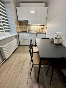 a kitchen with a table and a dining room at Swan City Family Apartment in Gulbene