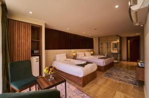 una habitación de hotel con 2 camas y una silla en New Pyramid Front Hotel en El Cairo
