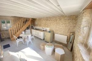 una cocina y comedor en una casa con paredes de ladrillo en Charming little house with exposed stonework en Luc-sur-Mer