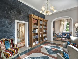 a living room with bookshelves and a chandelier at La Villa in Siena