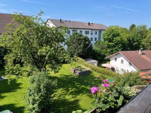 a view of a yard with flowers and a building at Ferienwohnung Hofer in Altötting
