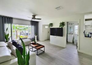 a living room with a white couch and a tv at DreamHouse with Heated Pool in Fort Lauderdale