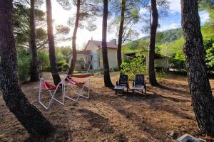 eine Sitzgruppe im Schatten der Bäume in der Unterkunft Villa l’oliveraie in Sanary-sur-Mer