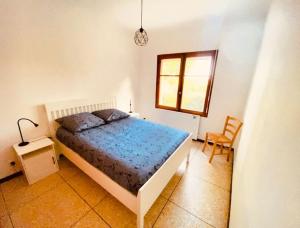 ein Schlafzimmer mit einem Bett, einem Stuhl und einem Fenster in der Unterkunft Villa l’oliveraie in Sanary-sur-Mer