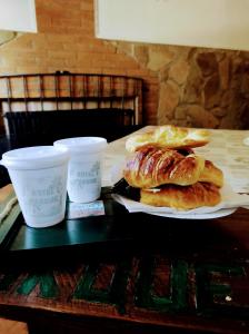 una mesa con dos platos de repostería y dos tazas en HOTEL PARQUE en Merlo- Buenos Aires en Merlo