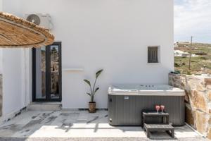 eine Whirlpool-Badewanne in einem weißen Gebäude mit Fenster in der Unterkunft Delight Apartments suites in Stelida