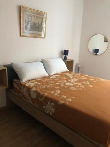un letto con due cuscini e uno specchio a parete di PLACE MASSENA a Nizza