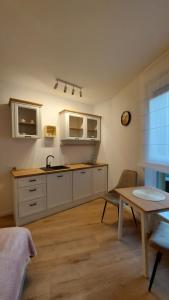 a kitchen with a sink and a table at Pachnące Sny Apartament in Elblag