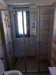 e bagno con doccia, servizi igienici e finestra. di CASA LUCIA , ricarica auto elettrica GRATUITA a Siniscola