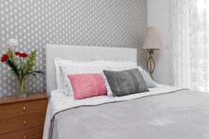ein Schlafzimmer mit einem weißen Bett und einer Blumenvase in der Unterkunft Charming Appt in Preveza