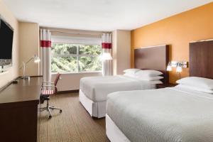 a hotel room with two beds and a desk at Four Points by Sheraton Surrey in Surrey