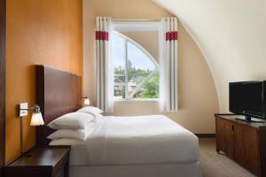 Habitación de hotel con cama y ventana en Four Points by Sheraton Surrey, en Surrey