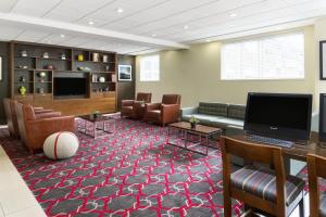 a waiting room with a couch and a television at Four Points by Sheraton Surrey in Surrey