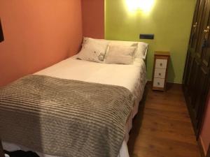 een kleine slaapkamer met een bed en een nachtkastje bij Apartamento Cervantes - Piedad Fernandez Fernandez Gestión de Inmuebles SL in Béjar