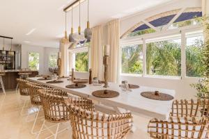 a kitchen with a long table with chairs and windows at ARCADIA - AVENIDA 28 De LAS ADELFAS 29680 ESTEPONA, MALAGA in Estepona