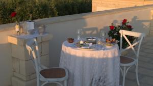 a table with a white table cloth and two chairs at Casale Giuseppe in Fasano