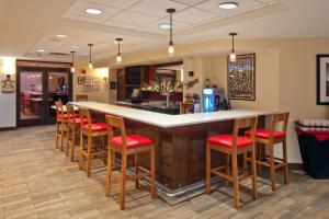 un bar con taburetes rojos en un restaurante en Four Points by Sheraton Nashville Airport, en Nashville