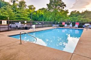 a swimming pool with chairs and a fence at Four Points by Sheraton Nashville Airport in Nashville