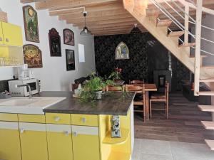 uma cozinha com armários amarelos e uma sala de jantar em Les gîtes de L'hermine em Plouigneau