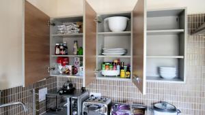 a kitchen with a sink and shelves with dishes at Keniji Luxury 2 Bed Apartment in Milton Keynes