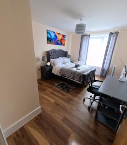 a bedroom with a bed and a desk at Keniji Luxury 2 Bed Apartment in Milton Keynes