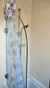 a shower curtain in a bathroom with a tub at Keniji Luxury 2 Bed Apartment in Milton Keynes