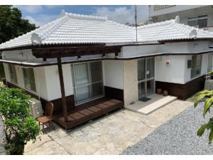 ein Haus mit einer Veranda und einem Dach in der Unterkunft Condominium WAFU TEI Okinawa city / Vacation STAY 58897 in Okinawa