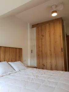 a bedroom with a white bed and a wooden door at Piedad Fernandez Fernandez Gestion de Inmuebles V in Barreiros