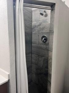 a shower with a white shower curtain in a bathroom at Suburban Studios Portage in Portage +24 photos
