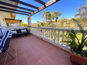 einen Balkon mit Blick auf Palmen in der Unterkunft Precioso Apartamento Puerto Banus Marbella in Marbella