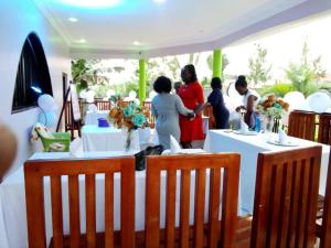 a group of people standing around tables with flowers at Palm Star Motel in Fort Portal