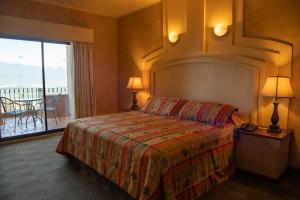 a hotel room with a bed and a balcony at Hotel Hacienda Cola del Caballo in Santiago