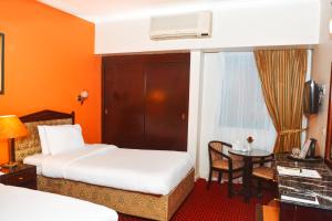 um quarto de hotel com duas camas e uma mesa em Gawharet Al Ahram Hotel no Cairo