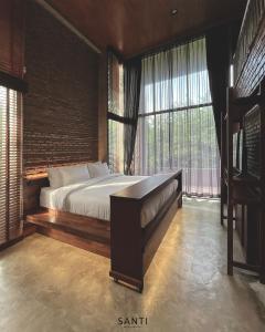 a bedroom with a bed and a large window at SANTI beach retreat in Ban Rang Pla