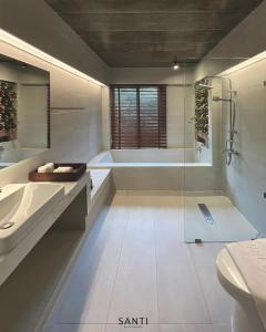 uma casa de banho com um chuveiro, um lavatório e uma banheira em SANTI beach retreat em Ban Rang Pla