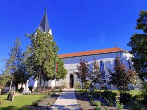 a church with a steeple on a clear day at Németh Vendégház -Torkos Fogadó in Ibrány +3 photos