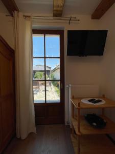 Zimmer mit einem Fenster, einem TV und einem Tisch in der Unterkunft Kis-Duna Vendégház in Dunabogdány